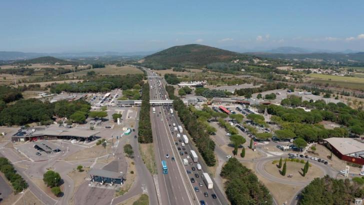 De part et d'autre d'une autoroute deux aires de repos et de restauration se rejoignent au moyen d'un passage aérien couvert